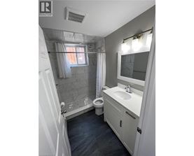 A bathroom with a toilet, sink, and shower.