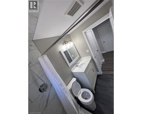 A bathroom with a toilet, sink, and mirror.