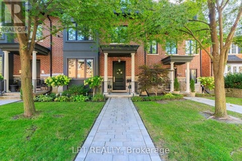 A brick house with a tree in front of it.