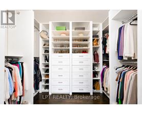 A white closet with drawers and clothes.