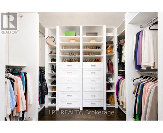 A white closet with drawers and clothes.