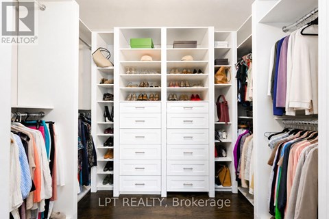 A white closet with drawers and clothes.