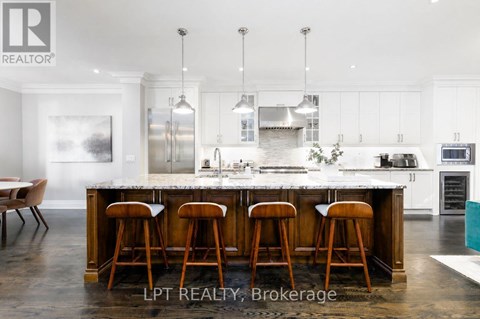 A modern kitchen with a large island and bar stools.