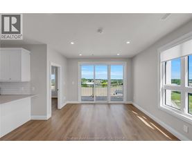 A well-lit, empty room with a view of the outdoors through a sliding glass door.