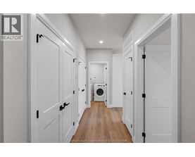 A hallway with white doors and a washing machine in the middle.
