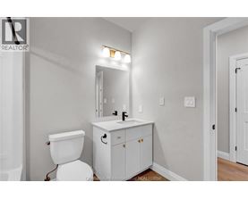 A white toilet sits next to a white sink in a bathroom.