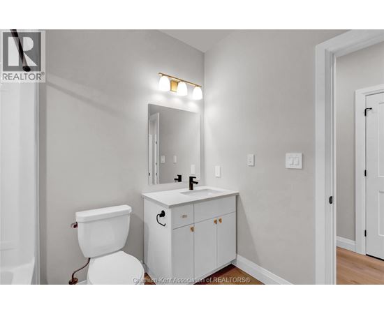 A white toilet sits next to a white sink in a bathroom.