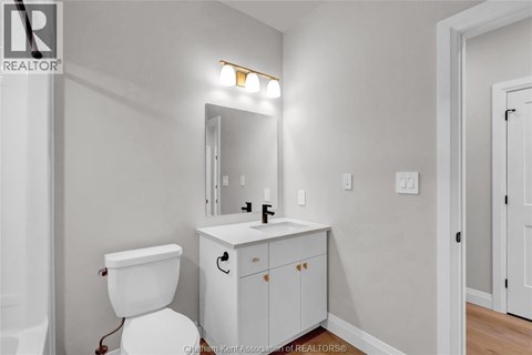 A white toilet sits next to a white sink in a bathroom.