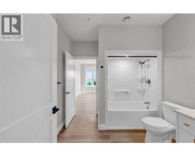 A white bathroom with a toilet, sink, and bathtub.