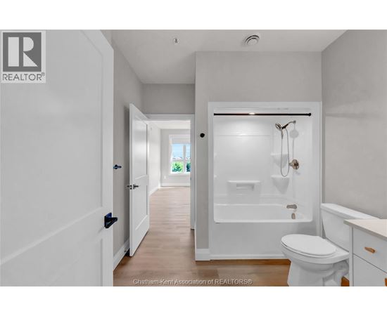 A white bathroom with a toilet, sink, and bathtub.