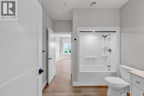 A white bathroom with a toilet, sink, and bathtub.