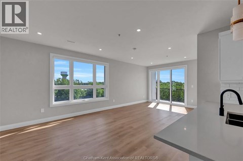 A spacious room with wooden floors and white walls.