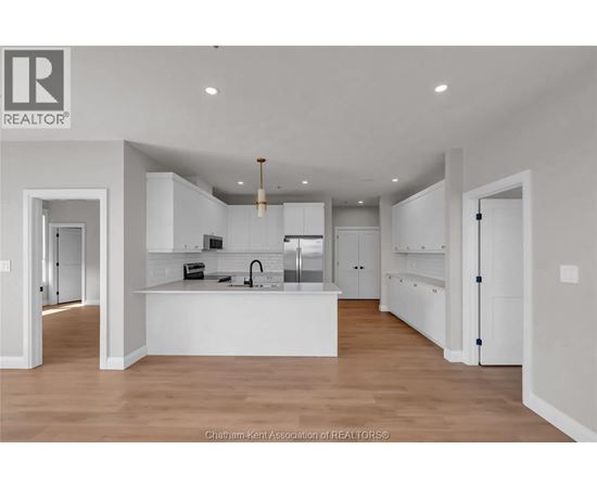 A modern kitchen with white cabinets and a central island.