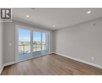 A room with a sliding glass door leading to a balcony.