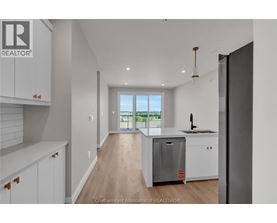A kitchen with white cabinets and a wooden floor.