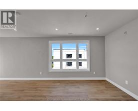 A room with a large window and wooden flooring.