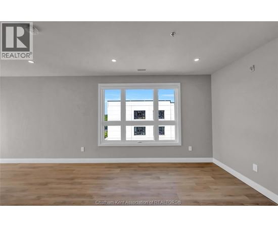 A room with a large window and wooden flooring.