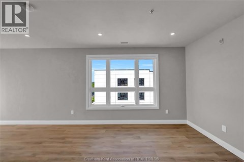 A room with a large window and wooden flooring.