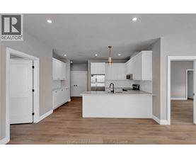A modern kitchen with white cabinets and a central island.