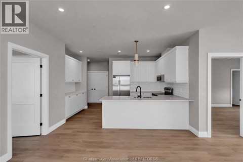 A modern kitchen with white cabinets and a central island.