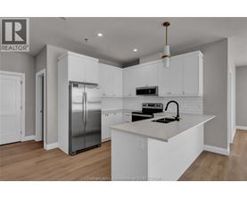 A modern kitchen with white cabinets and a stainless steel refrigerator.