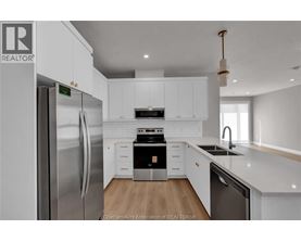 A modern kitchen with white cabinets and stainless steel appliances.