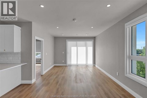 A spacious, empty room with a large window on the right side.