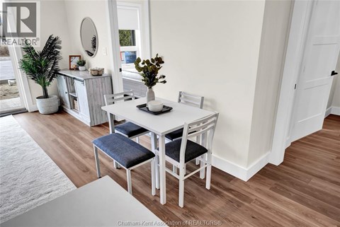 A dining room with a white table and chairs.