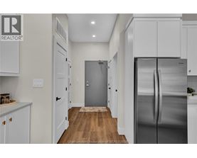 A kitchen with white cabinets and a stainless steel refrigerator.