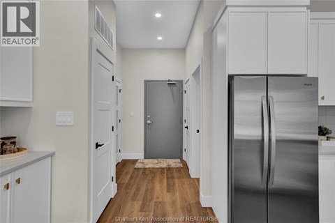A kitchen with white cabinets and a stainless steel refrigerator.