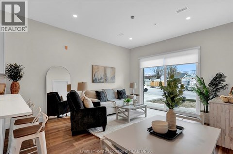 A living room with a white table and a black chair.