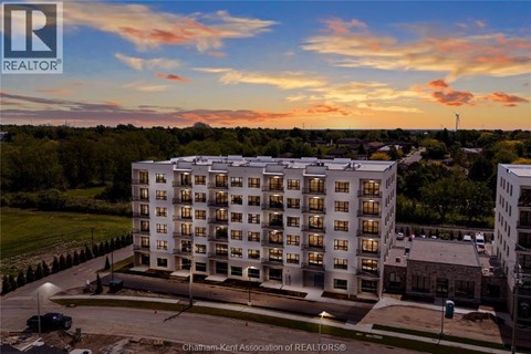 A large apartment building with a parking lot in front of it.