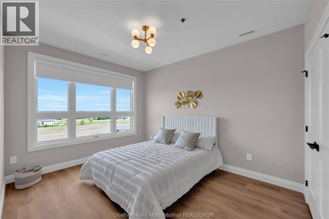 A bedroom with a large bed and a window overlooking a parking lot.
