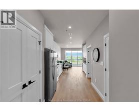 A long hallway with white doors and a window at the end.