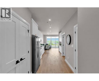 A long hallway with white doors and a window at the end.
