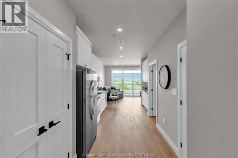 A long hallway with white doors and a window at the end.