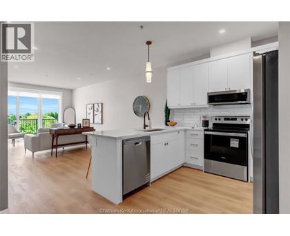 A modern kitchen with white cabinets and stainless steel appliances.