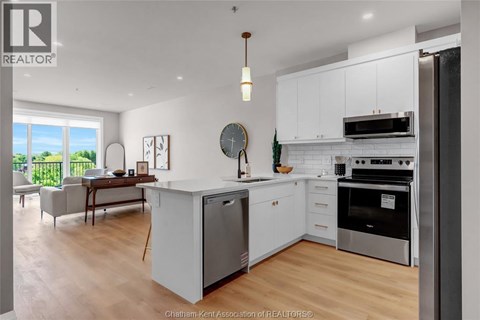 A modern kitchen with white cabinets and stainless steel appliances.