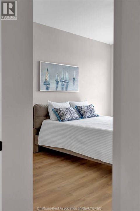 A bedroom with a bed and a painting on the wall.
