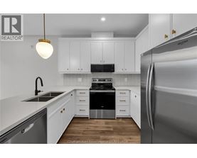 A kitchen with white cabinets and a stainless steel refrigerator.