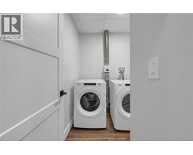 A laundry room with two washing machines and a door.