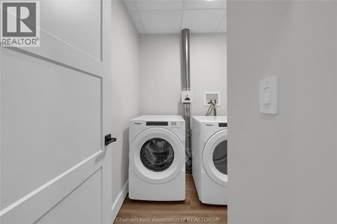 A laundry room with two washing machines and a door.