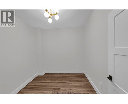 A room with a wooden floor and a white door.