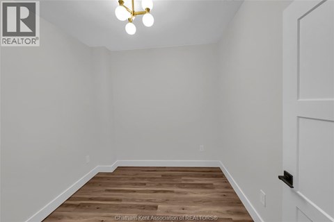 A room with a wooden floor and a white door.