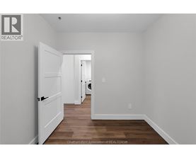 A white door is open in a room with wood flooring.
