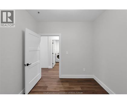 A white door is open in a room with wood flooring.