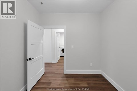 A white door is open in a room with wood flooring.