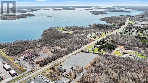 An aerial view of a construction site with a body of water in the background.