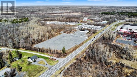 A real estate brokerage office is located in a wooded area with a road passing by.