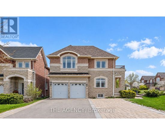 A large, two-story house with a brick facade and a driveway in front.